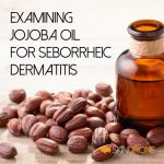 Cover image for article examining the use of Jojoba oil for the treatment of seborrheic dermatitis - article title text overlays a photo showing a bottle of Jojoba oil standing beside a pile of Jojoba beans on wooden surface